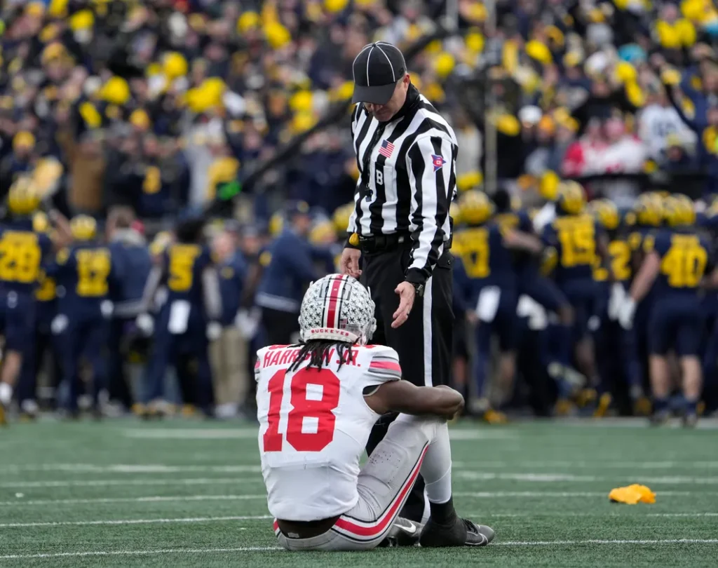 An official offers Ohio State receiver Marvin Harrison Jr. a hand during the second half of Saturday's loss at Michigan. Barbara J. Perenic/Columbus Dispatch