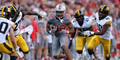 Oct 5, 2024; Columbus, Ohio, USA; Ohio State Buckeyes running back TreVeyon Henderson (32) runs the ball against Iowa Hawkeyes linebacker Nick Jackson (10) and defensive back Jermari Harris (27) during the fourth quarter at Ohio Stadium. Mandatory Credit: Joseph Maiorana-Imagn Images / Joseph Maiorana-Imagn Images