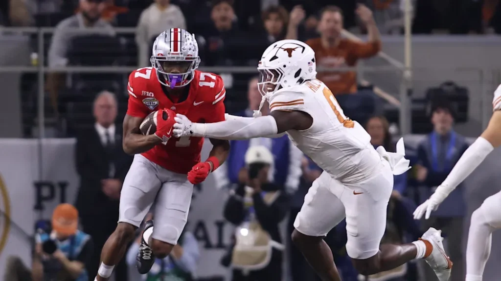 Jan 10, 2025; Arlington, Texas, USA; Ohio State Buckeyes wide receiver Carnell Tate (17) runs against Texas Longhorns linebacker Anthony Hill Jr. (0) during the first quarter of the College Football Playoff semifinal in the Cotton Bowl at AT&T Stadium. Mandatory Credit: Tim Heitman-Imagn Images | Tim Heitman-Imagn Images