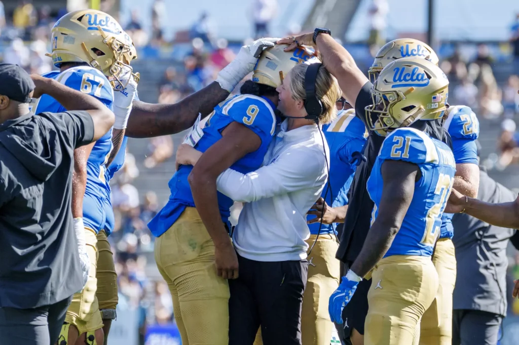 UCLA assistant coach Jerry Neuheisel hugs quarterback Nico Iamaleava (9) after he scored a touchdown and threw a two-point conversion pass against Penn State on Saturday at the Rose Bowl.(Gina Ferazzi / Los Angeles Times)