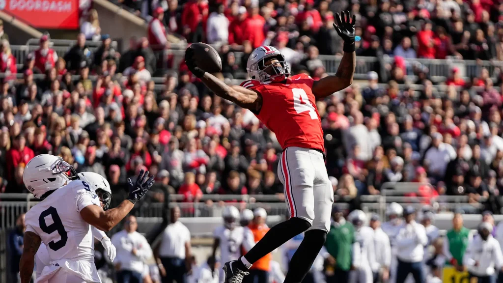 Ohio State Buckeyes wide receiver Jeremiah Smith (4) catches a touchdown pass in front of Penn State Nittany Lions cornerback Elliot Washington II (9) during the NCAA football game at Ohio Stadium in Columbus on Nov. 1, 2025. | Adam Cairns/Columbus Dispatch / USA TODAY NETWORK via Imagn Images