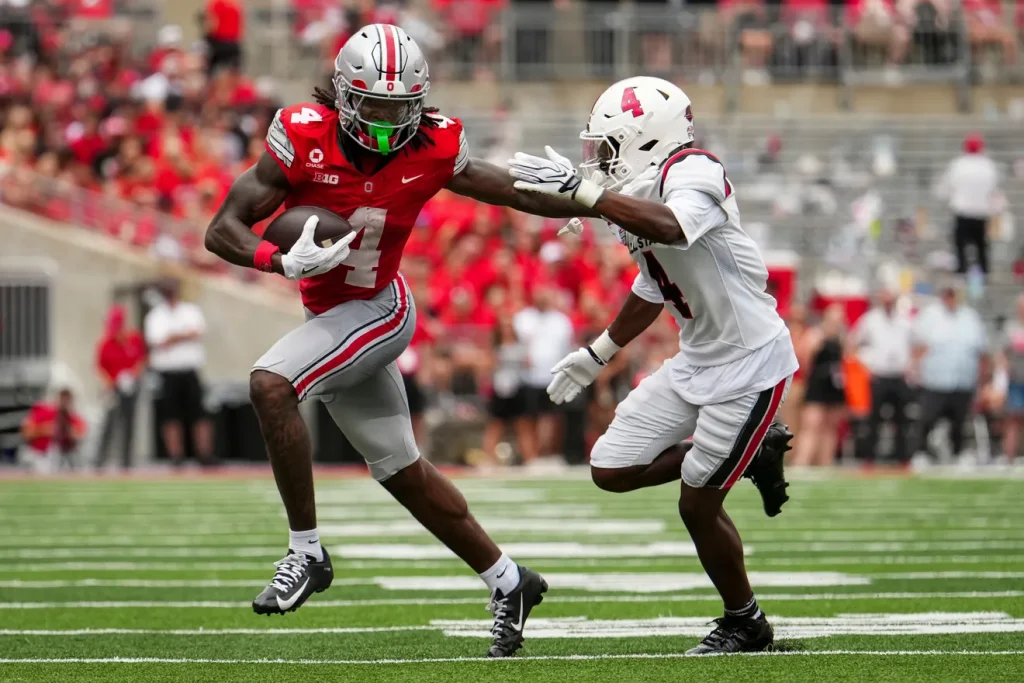 Ohio State Buckeyes wide receiver Jeremiah Smith (4) runs past Ball State Cardinals defensive back Willizhuan Yates (4) during the NCAA football game at Ohio Stadium in Columbus on Sept. 5, 2026. | Adam Cairns/Columbus Dispatch, USA TODAY Network Via Reuters Co