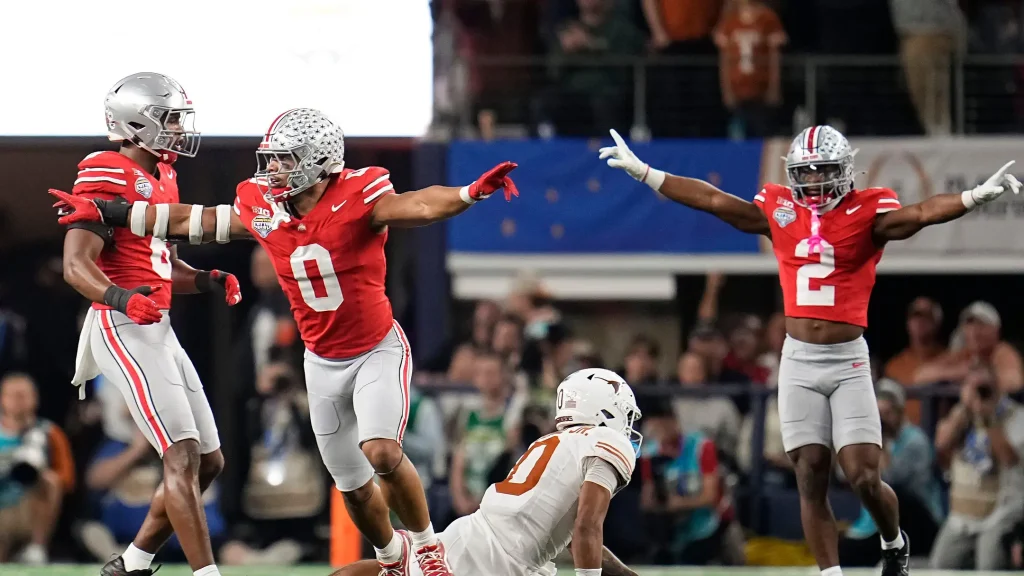 Ohio State Buckeyes linebacker Cody Simon (0) and safety Caleb Downs (2) celebrate a fourth down stop on a pass intended for Texas Longhorns wide receiver DeAndre Moore Jr. (0) during the first half of the Cotton Bowl Classic College Football Playoff semifinal game at AT&T Stadium in Arlington, Texas on Jan. 10, 2025. | Adam Cairns/Columbus Dispatch / USA TODAY NETWORK via Imagn Images