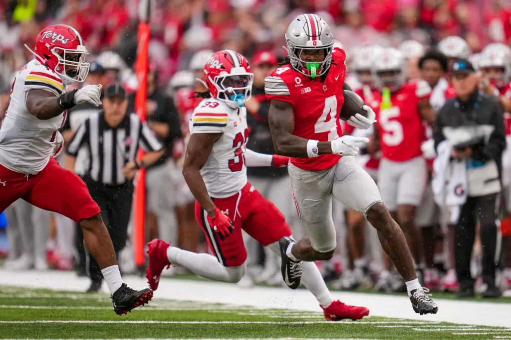 Ohio State Buckeyes wide receiver Jeremiah Smith (4) scores a touchdown past Maryland Terrapins defensive back Messiah Delhomme (33) during the NCAA football game at Ohio Stadium in Columbus on Oct. 10, 2026. Adam Cairns/Columbus Dispatch